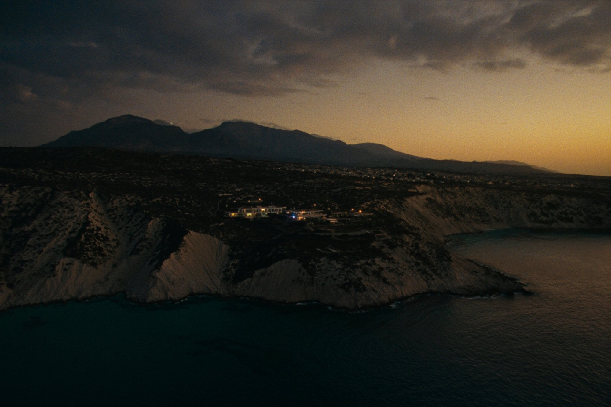 The Northern Cyprus coastline at dusk with a modern villa on the headland